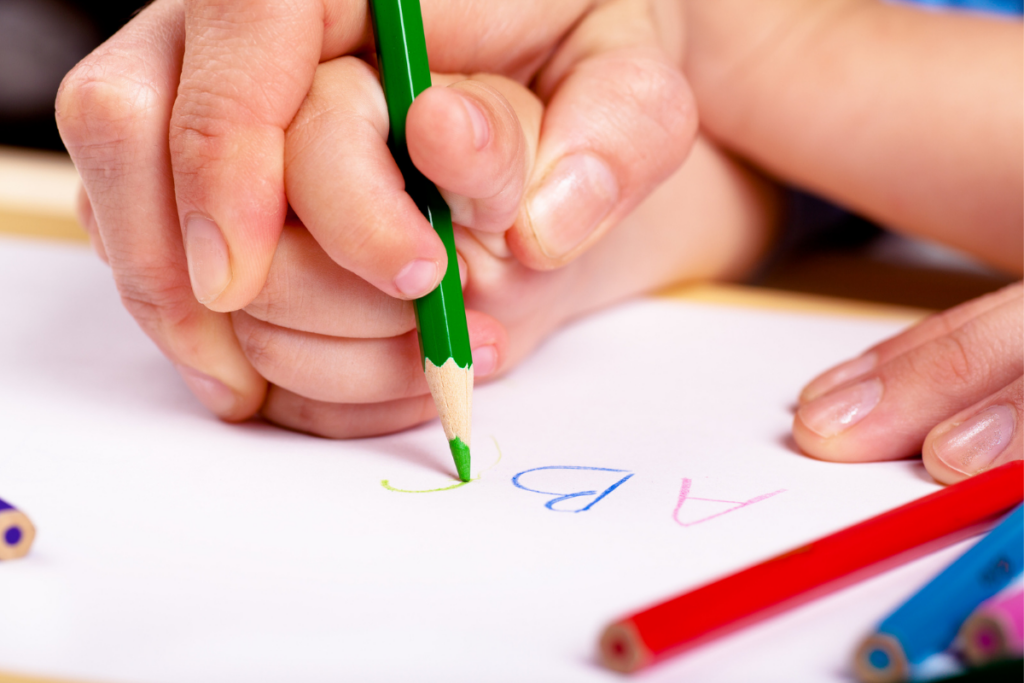 preschooler writing letters of the alphabet