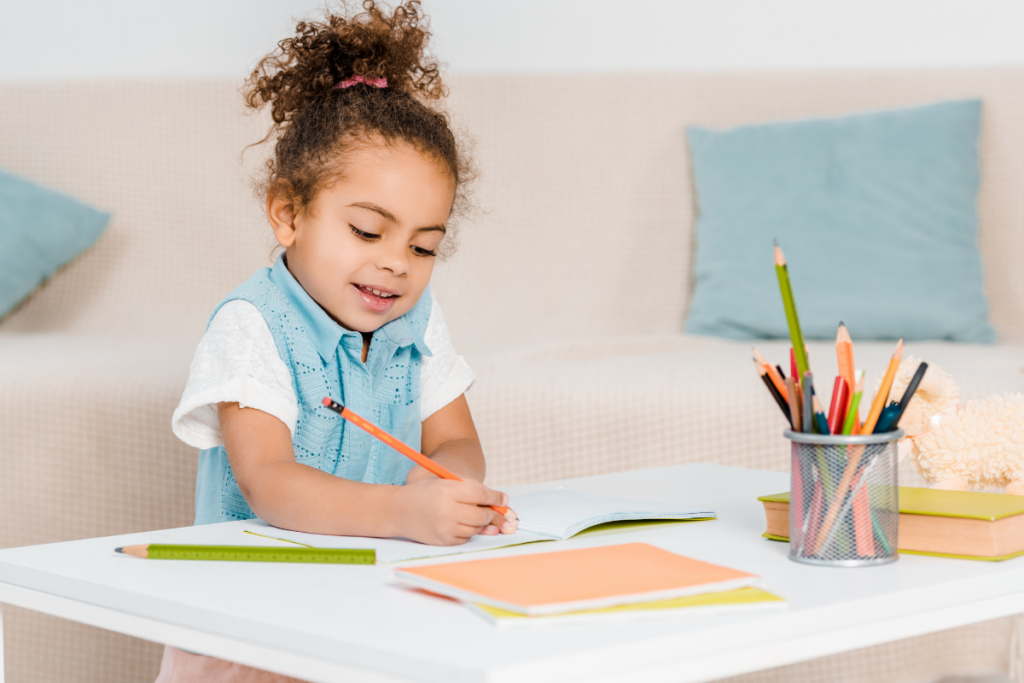 preschool child holding pencil working on tracing worksheets for preschoolers