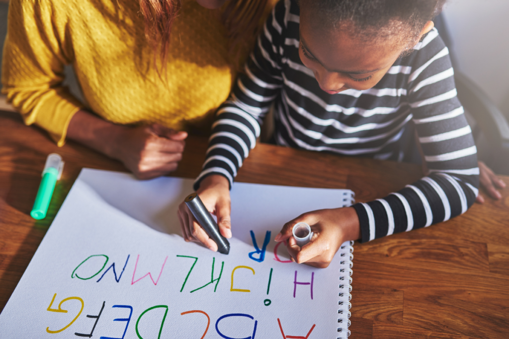 mom helping preschooler learn to write