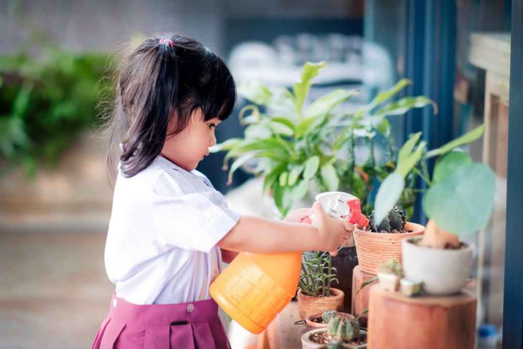preschool girl watering plants in the garden