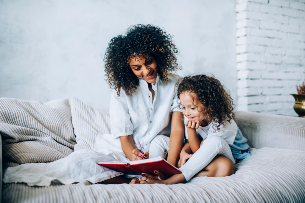 preschool child reading and writing with mom